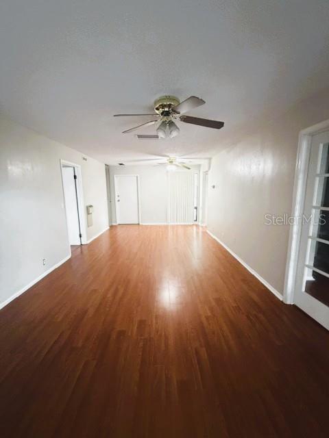 An empty room features wood-look flooring, a ceiling fan, and white walls — 419 SHEOAH BOULEVARD UNIT 28, WINTER SPRINGS, FL