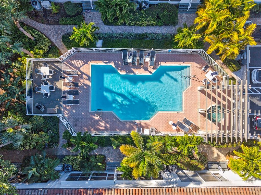 An aerial view shows a residential complex with tiled roofs near a coastal waterway — 903 PINELLAS BAYWAY S UNIT 308, TIERRA VERDE, FL