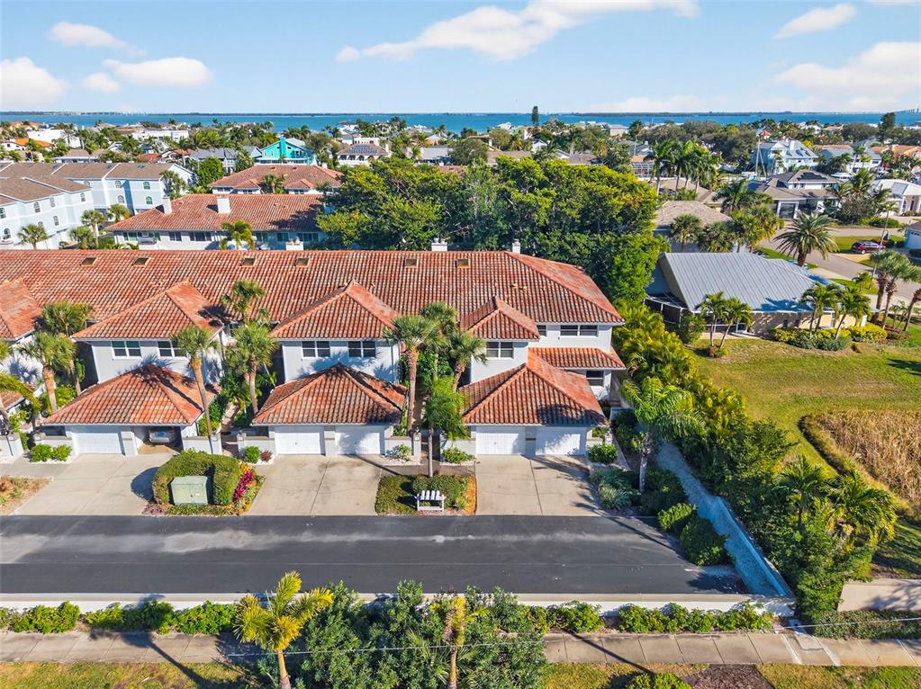 An aerial view shows a swimming pool with a deck, lounge chairs, and a pergola — 903 PINELLAS BAYWAY S UNIT 308, TIERRA VERDE, FL
