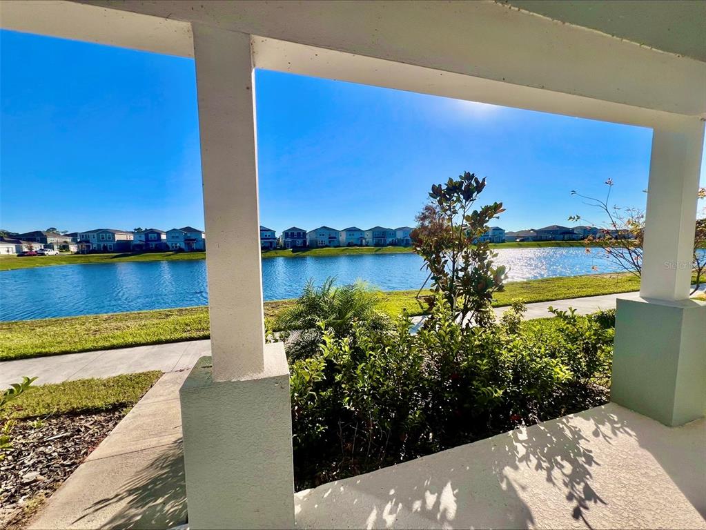 A view of a lake and neighborhood houses from a covered patio — 6098 WINDY LEAF ALY, ST CLOUD, FL