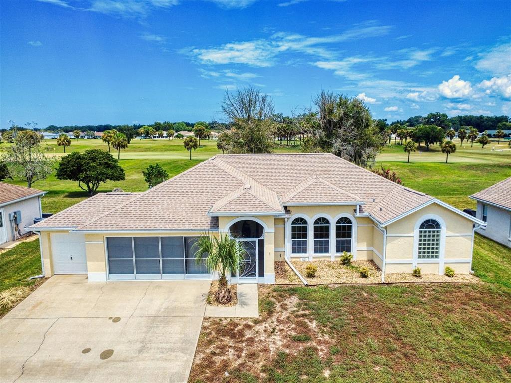 An aerial view of a single-story yellow house with a screened porch and golf course — 2089 NW 50TH CIRCLE, OCALA, FL