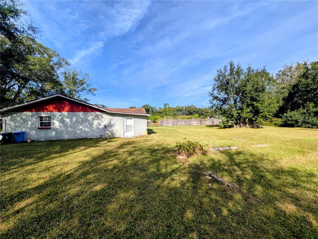 A white exterior building with a red trim roof sits on a grassy lot — 8410 PETERSON ROAD, ODESSA, FL