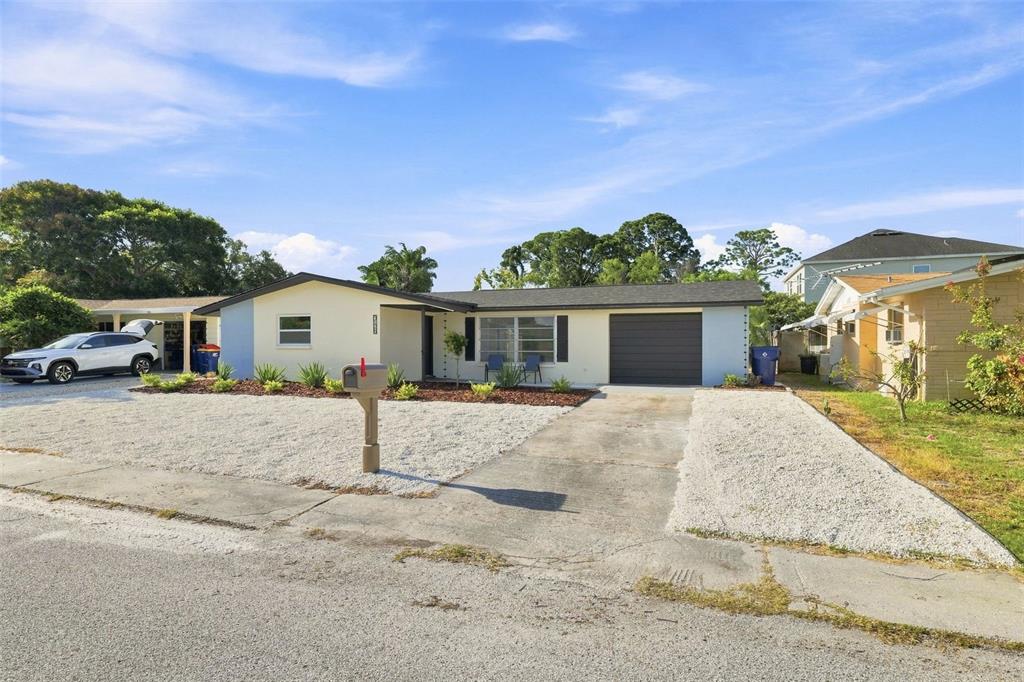 A single-story house with a gravel front yard, a concrete driveway, and a garage — 3128 HARVARDSTON LOOP, HOLIDAY, FL