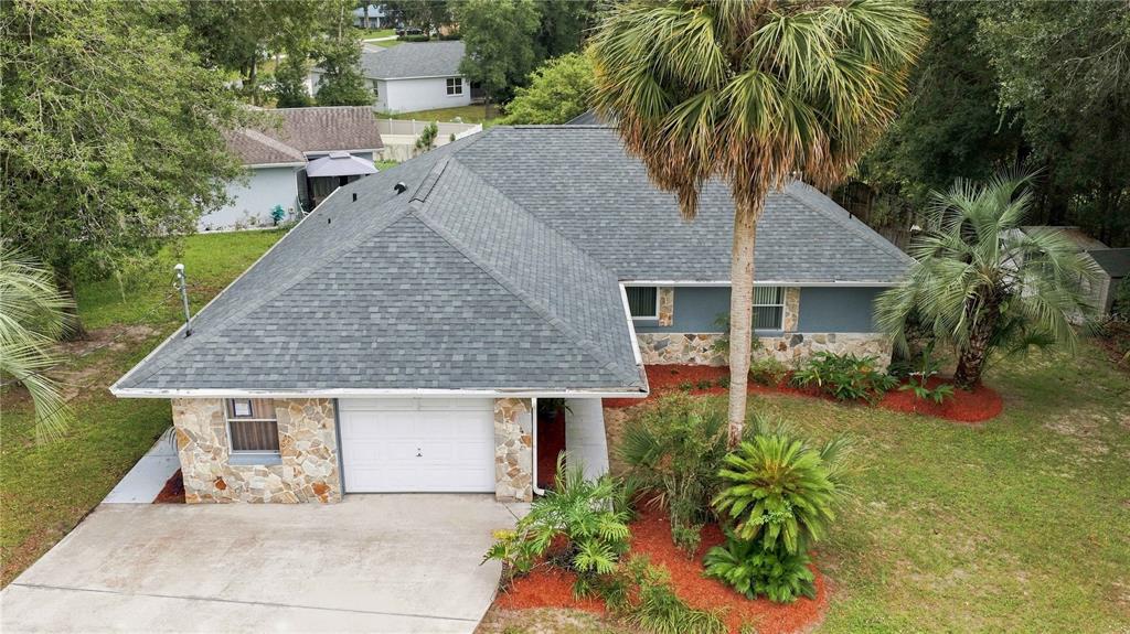 An aerial view of a single-story house with a gray shingled roof and stone facade — 6500 CHERRY ROAD, OCALA, FL