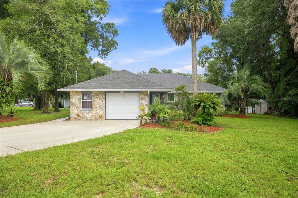 A single-story house with a stone facade, a one-car garage, and a large grassy yard — 6500 CHERRY ROAD, OCALA, FL