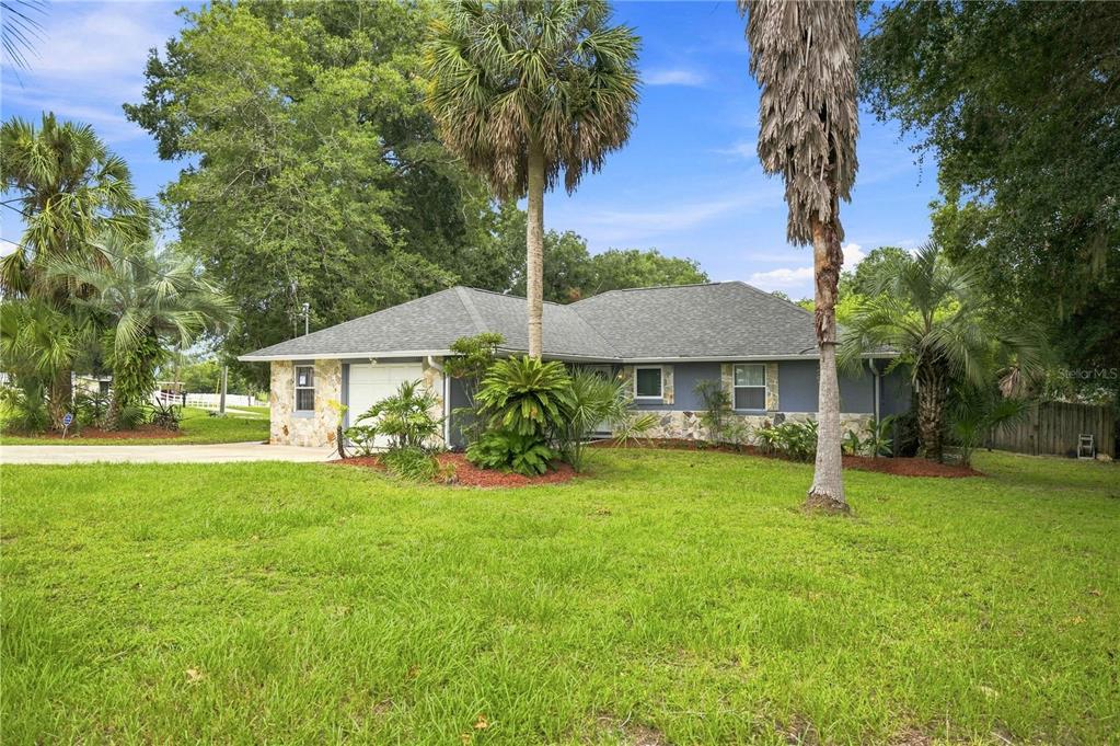 A single-story house with a stone facade, gray siding, and a large front lawn — 6500 CHERRY ROAD, OCALA, FL