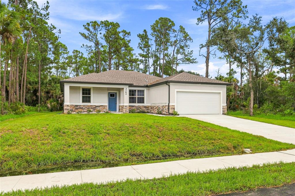 A single-story house with a blue front door, stone veneer, and a two-car garage — 3762 SARDINIA AVENUE, NORTH PORT, FL