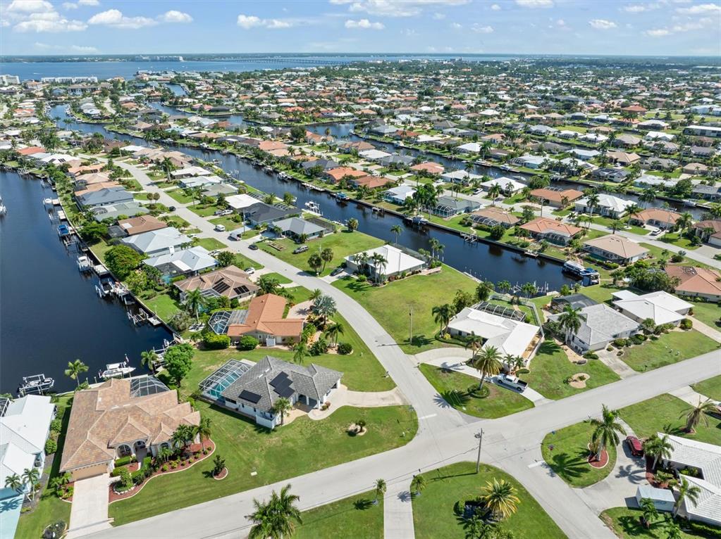 An aerial view shows waterfront homes with private docks along canals in a residential neighborhood — 834 SANTA MARGERITA LANE, PUNTA GORDA, FL