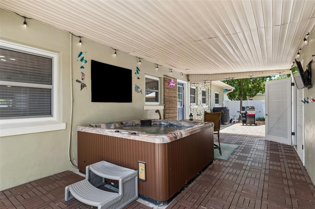 A living room features a sectional sofa, a television above a fireplace console, and hardwood floors — 604 7TH AVENUE SW, LARGO, FL