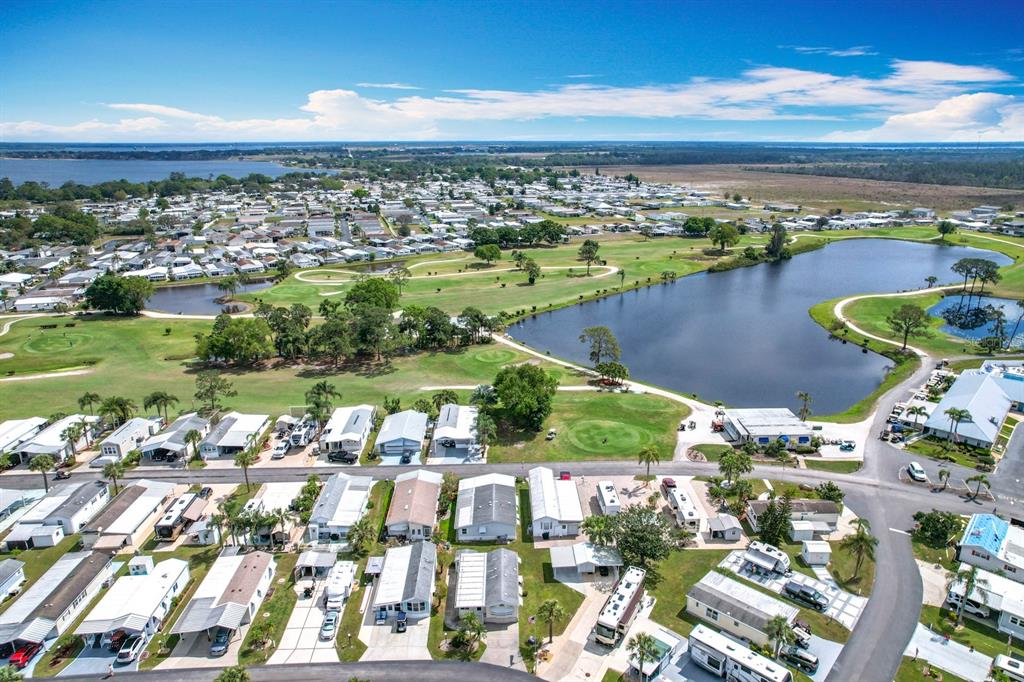 An aerial view shows a residential community with mobile homes surrounding a golf course and lake — 190 BIG PINE AVENUE S, FROSTPROOF, FL