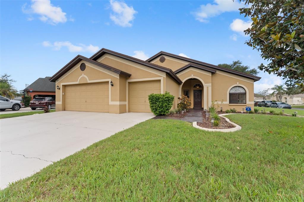A tan single-story house with a two-car garage and a front walkway — 1803 CATTLEMAN DRIVE, BRANDON, FL