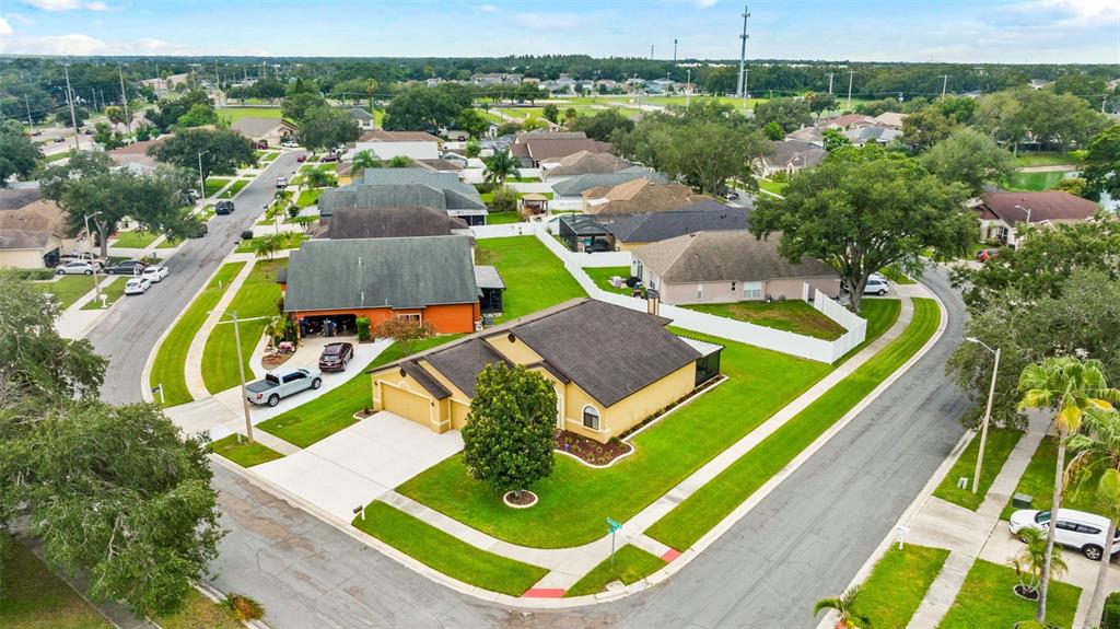 An aerial view shows a suburban neighborhood with single-family homes, manicured lawns, and paved streets — 1803 CATTLEMAN DRIVE, BRANDON, FL