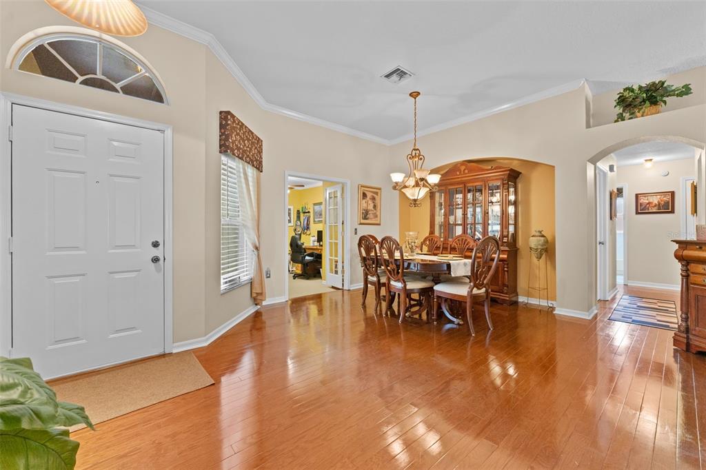 A dining room with hardwood floors, a wooden hutch, and a chandelier near the entryway — 1803 CATTLEMAN DRIVE, BRANDON, FL