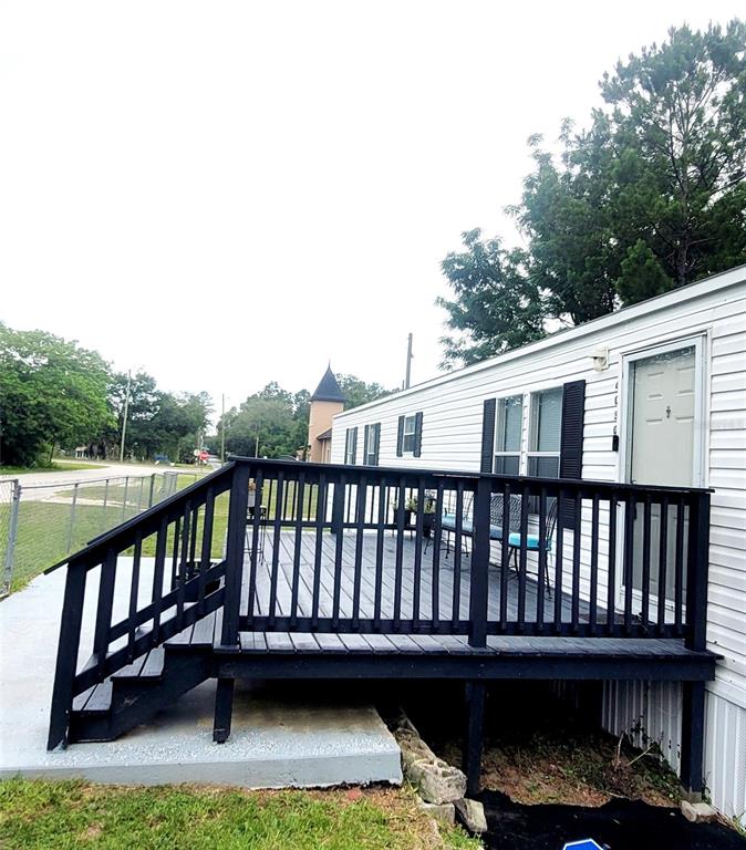 A white six-panel door is centered on a plain wall above wood-look flooring — 4030 NE 212TH TERRACE, WILLISTON, FL