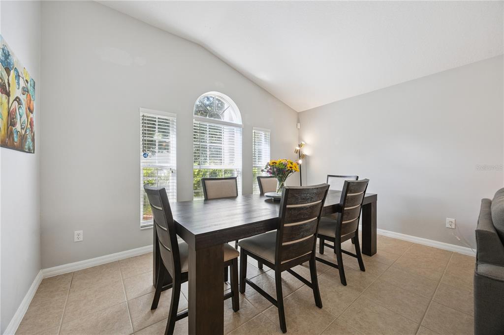 An entryway with light-colored walls, tile flooring, a white front door, and a potted plant — 11625 GREAT COMMISSION WAY, ORLANDO, FL