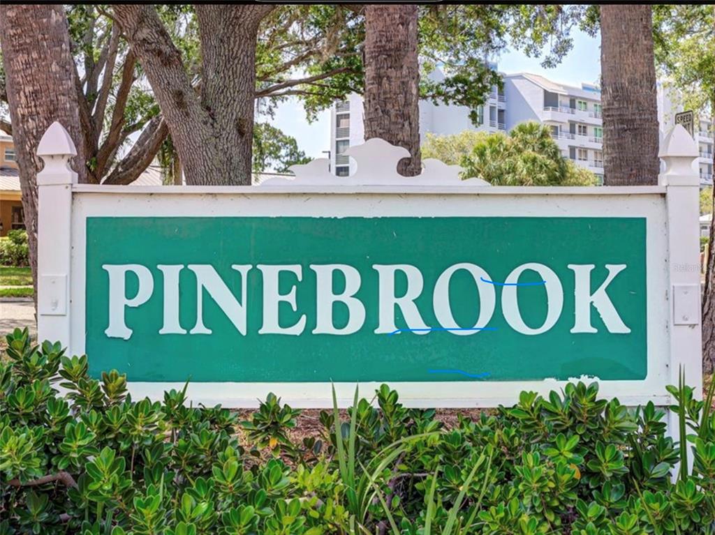 A white sign with the word PINEBROOK in large white letters on a green background — 4570 PINEBROOK CIRCLE CIRCLE UNIT 404, BRADENTON, FL