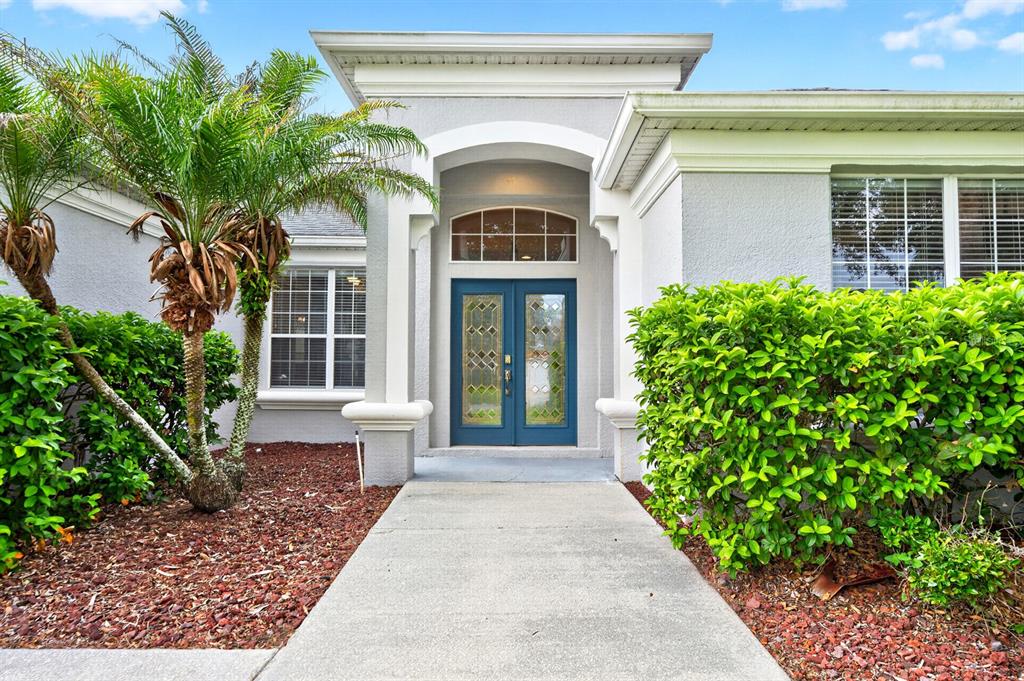 A foyer with tile flooring leads into a dining room featuring hardwood floors and chandeliers — 13537 KITTY FORK ROAD, ORLANDO, FL