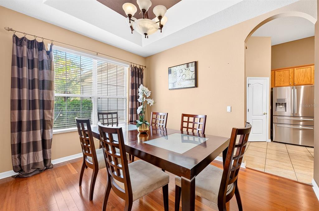 A kitchen features oak cabinets, stainless steel appliances, a center island, and tiled flooring — 13537 KITTY FORK ROAD, ORLANDO, FL