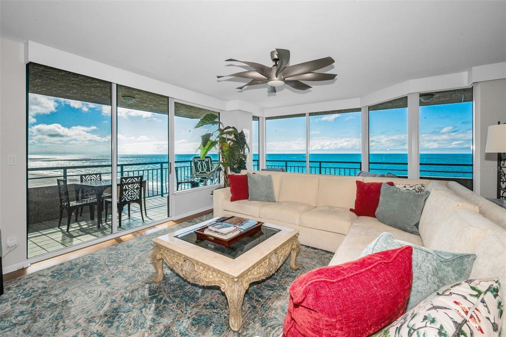 Two armchairs and a small table sit before large windows overlooking the ocean — 1520 GULF BOULEVARD UNIT 1101, CLEARWATER BEACH, FL