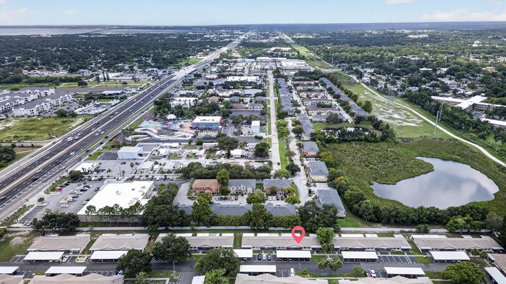 An aerial view shows a residential complex with covered parking and a nearby highway — 24862 US HIGHWAY 19 N UNIT 3305, CLEARWATER, FL