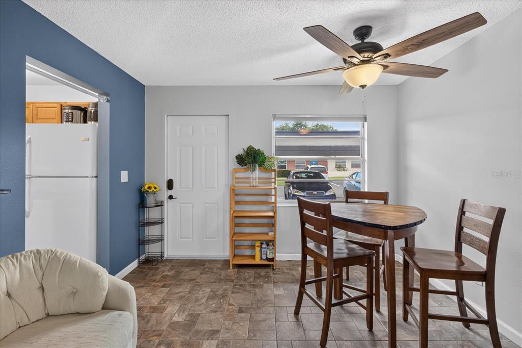 A dining area features a wooden table, chairs, a ceiling fan, and a blue accent wall — 24862 US HIGHWAY 19 N UNIT 3305, CLEARWATER, FL