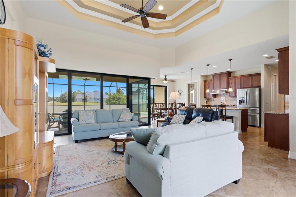 A kitchen features wood cabinets, granite countertops, a center island with seating, and tile flooring — 60 HARNESS ROAD, PLACIDA, FL