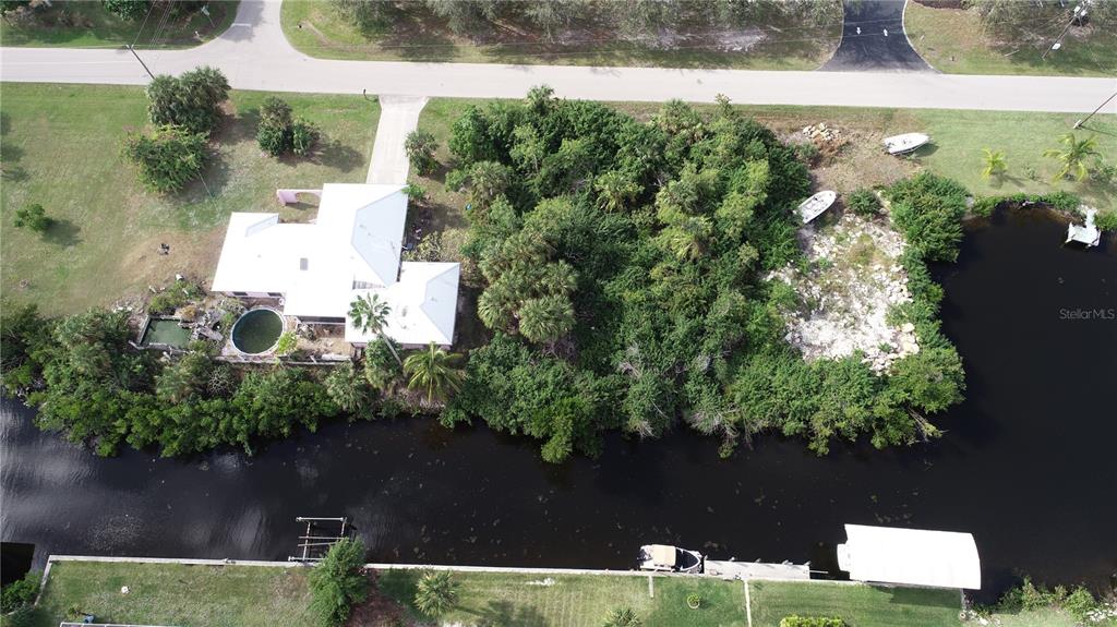 An aerial view shows a house with a pool and boat dock on a canal — 4114 PALM DRIVE, PUNTA GORDA, FL