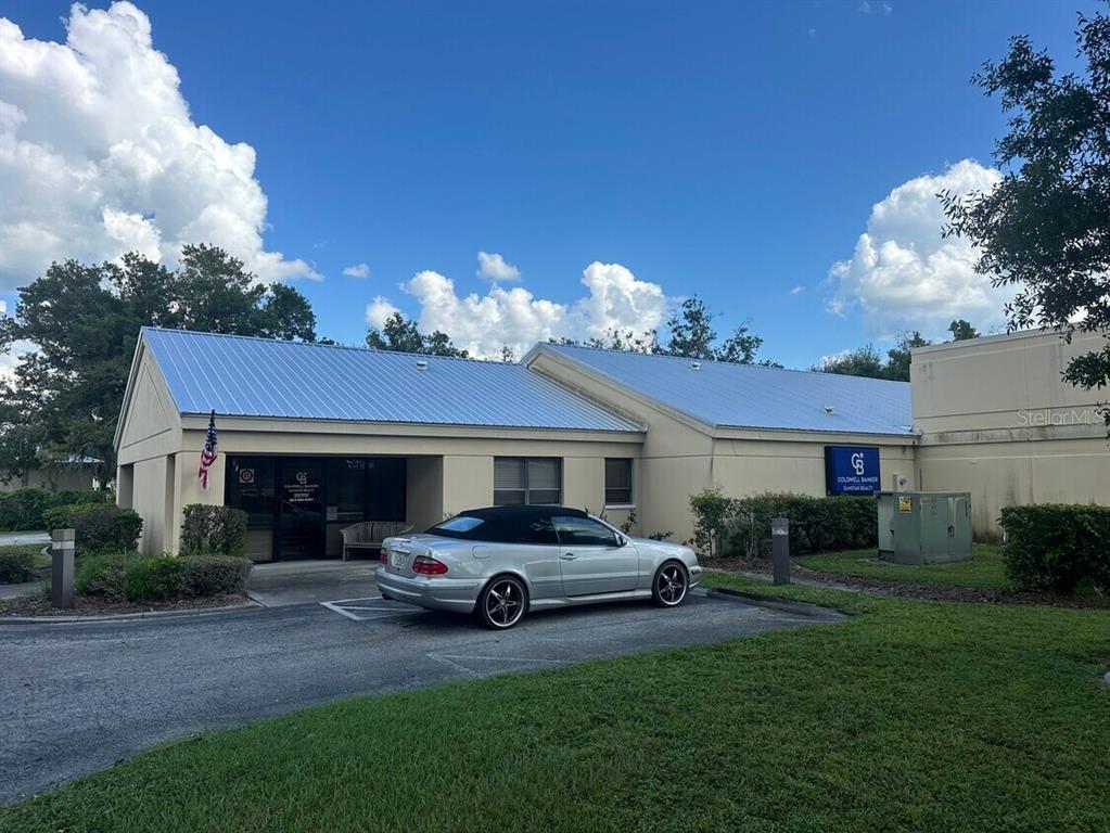 A silver convertible is parked in front of a single-story commercial building with a metal roof — 920 N MILLS AVENUE, ARCADIA, FL