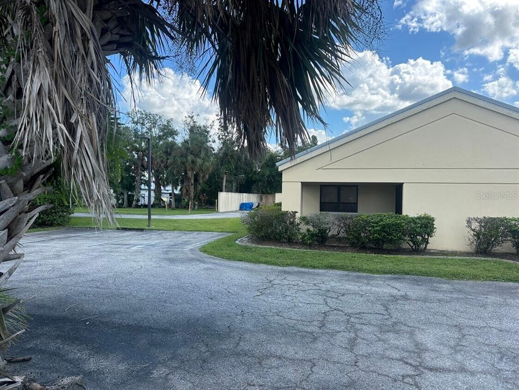 A paved parking lot sits in front of a beige building with a palm tree — 920 N MILLS AVENUE, ARCADIA, FL