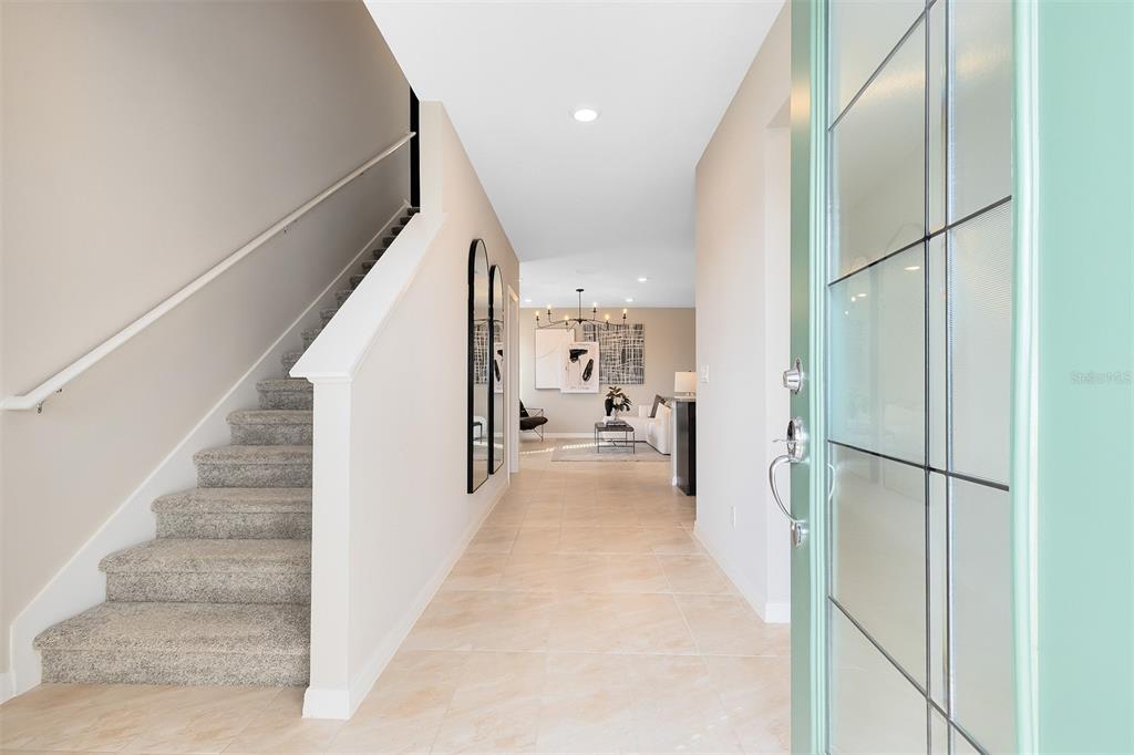 An entryway features a carpeted staircase, tile flooring, and a view into a living area — 1263 GARDENERS PLACE, ORLANDO, FL