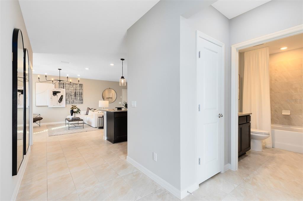 A hallway with tile flooring leads to a living area and a bathroom with a shower — 1263 GARDENERS PLACE, ORLANDO, FL