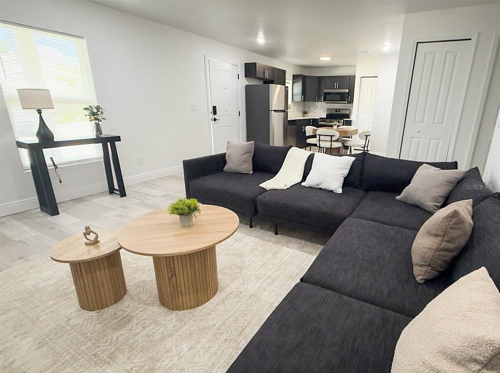 An empty bedroom features light gray walls, wood-look flooring, and a single window — 2201 CONWAY DRIVE UNIT 102, DELTONA, FL