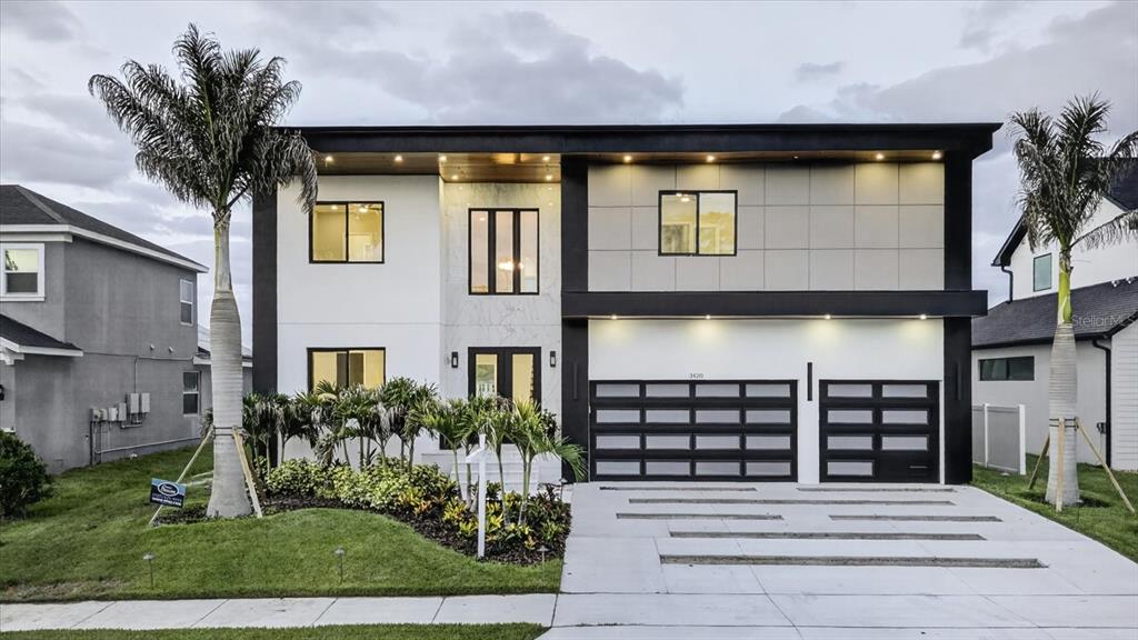 A bright foyer features a floating staircase, double glass doors, and white marble-look tile flooring — 3420 CHANNELSIDE COURT, SAFETY HARBOR, FL
