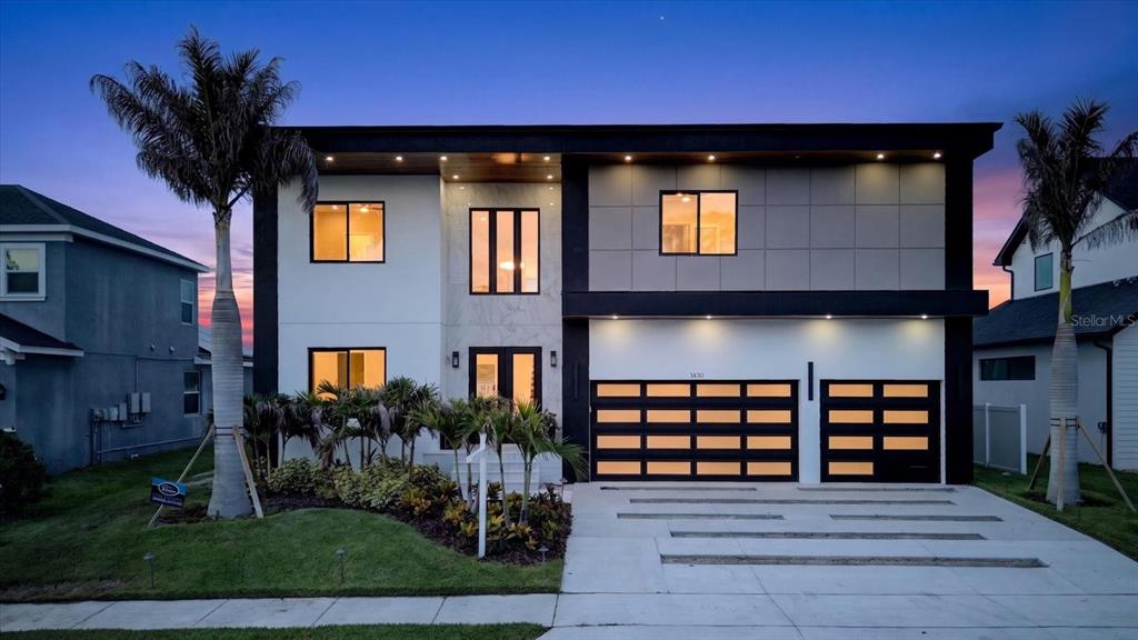 A two-story modern house with a white facade, black trim, and a two-car garage — 3420 CHANNELSIDE COURT, SAFETY HARBOR, FL