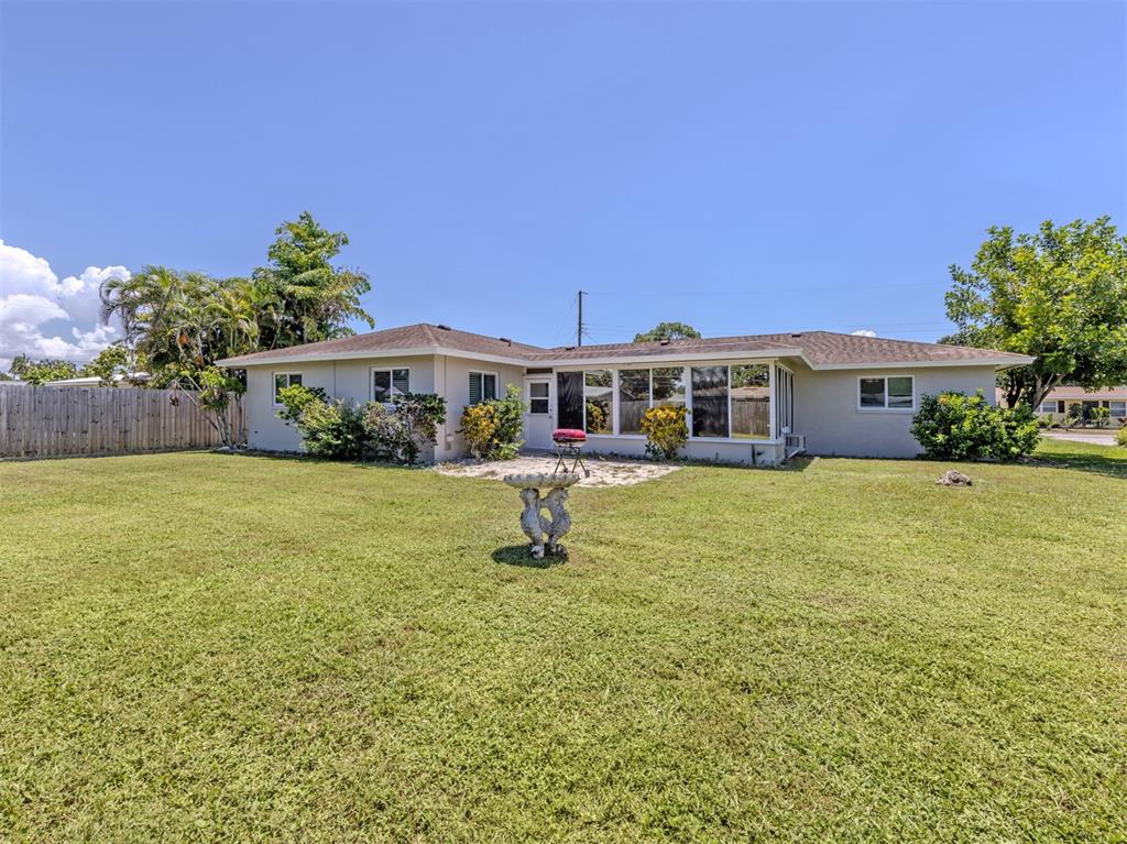 The exterior of a single-story house features a large grassy lawn and a rear patio — 2161 INNER CASS CIRCLE, SARASOTA, FL