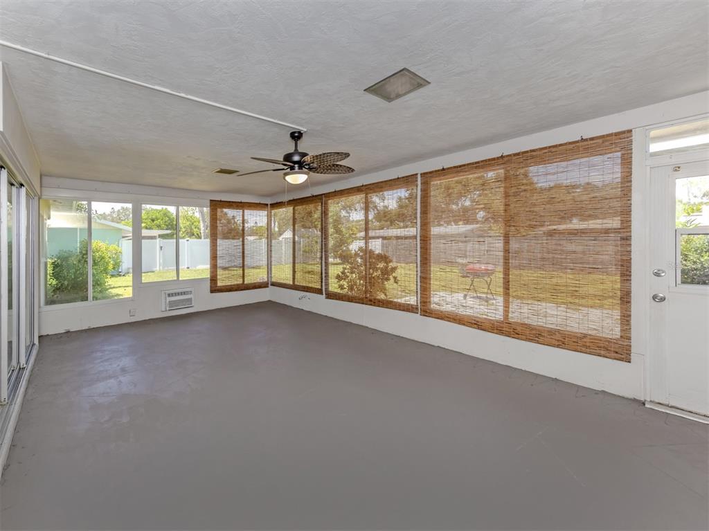 A sunroom with gray painted floors, a ceiling fan, and bamboo shades covering the windows — 2161 INNER CASS CIRCLE, SARASOTA, FL