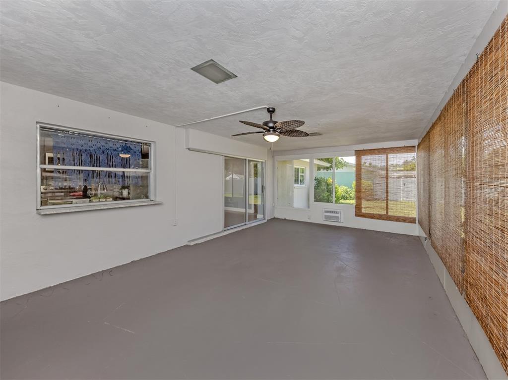 A sunroom with gray painted floors, a ceiling fan, and bamboo shades over the windows — 2161 INNER CASS CIRCLE, SARASOTA, FL
