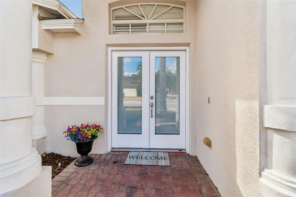 A front entryway features double glass doors with blinds, a welcome mat, and a flower pot — 353 BAY ARBOR BOULEVARD, OLDSMAR, FL