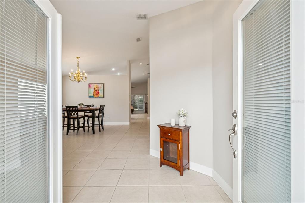 A view from an entryway looking into a dining area with tile floors and a chandelier — 353 BAY ARBOR BOULEVARD, OLDSMAR, FL
