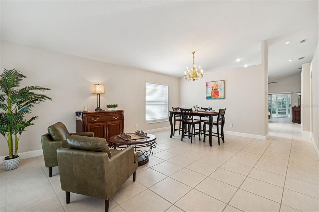 A dining and living area features tile floors, two leather armchairs, and a dining set — 353 BAY ARBOR BOULEVARD, OLDSMAR, FL
