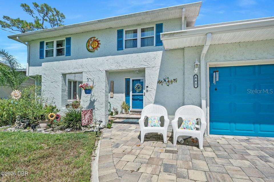 A two-story house with a blue garage door, white wicker chairs, and a stone patio — 461 ANDREWS STREET, ORMOND BEACH, FL