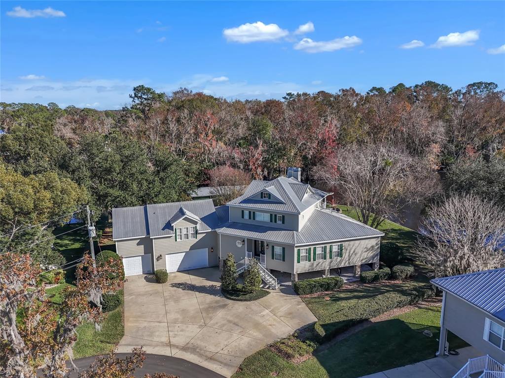 An aerial view of a multi-story house with a metal roof and attached garage — 56633 OTTER ROAD, ASTOR, FL