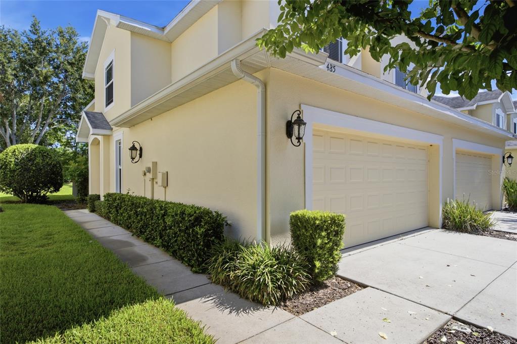 A two-story house with a beige exterior, a two-car garage, and a concrete driveway — 485 HARBOR RIDGE DRIVE, PALM HARBOR, FL