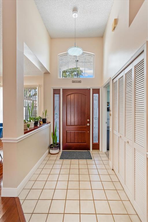 A living room features hardwood floors, a vaulted ceiling with a fan, and glass doors — 2821 LONE FEATHER DRIVE, ORLANDO, FL