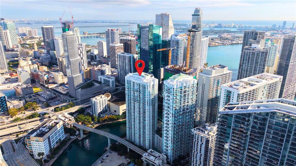 An aerial view of a high-rise residential building in a dense urban waterfront city — 31 SE 5TH STREET UNIT 203, MIAMI, FL