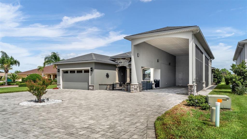 A house exterior features a paved driveway, a two-car garage, and a large covered entryway — 790 TEABERRY TRAIL, POLK CITY, FL