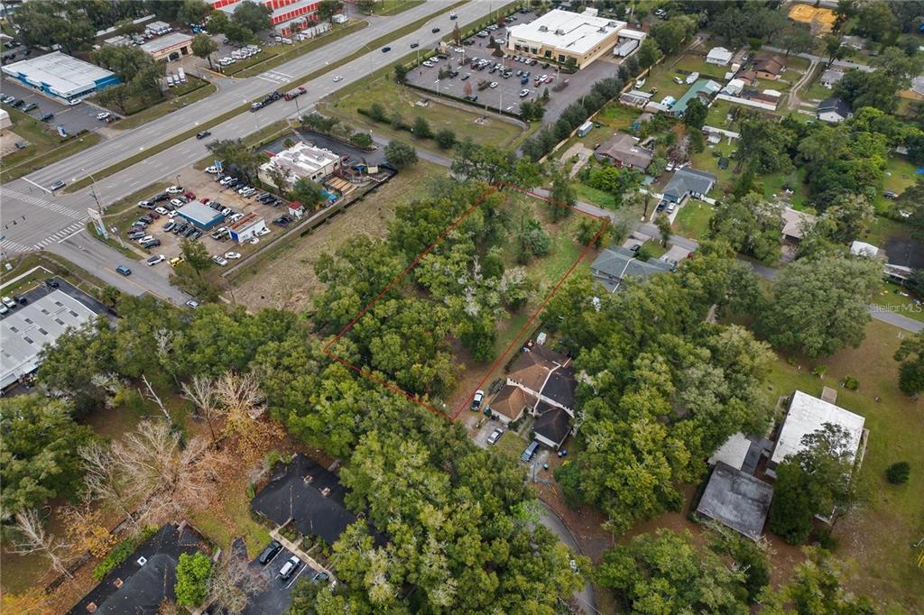 An aerial view shows a wooded lot outlined in red next to a residential house — SAND AVENUE, APOPKA, FL