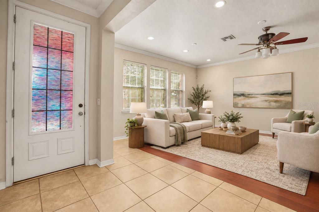 A living room with tile flooring, wood floors, a ceiling fan, and a front door — 561 TELFAIR SQUARE COURT, SANFORD, FL