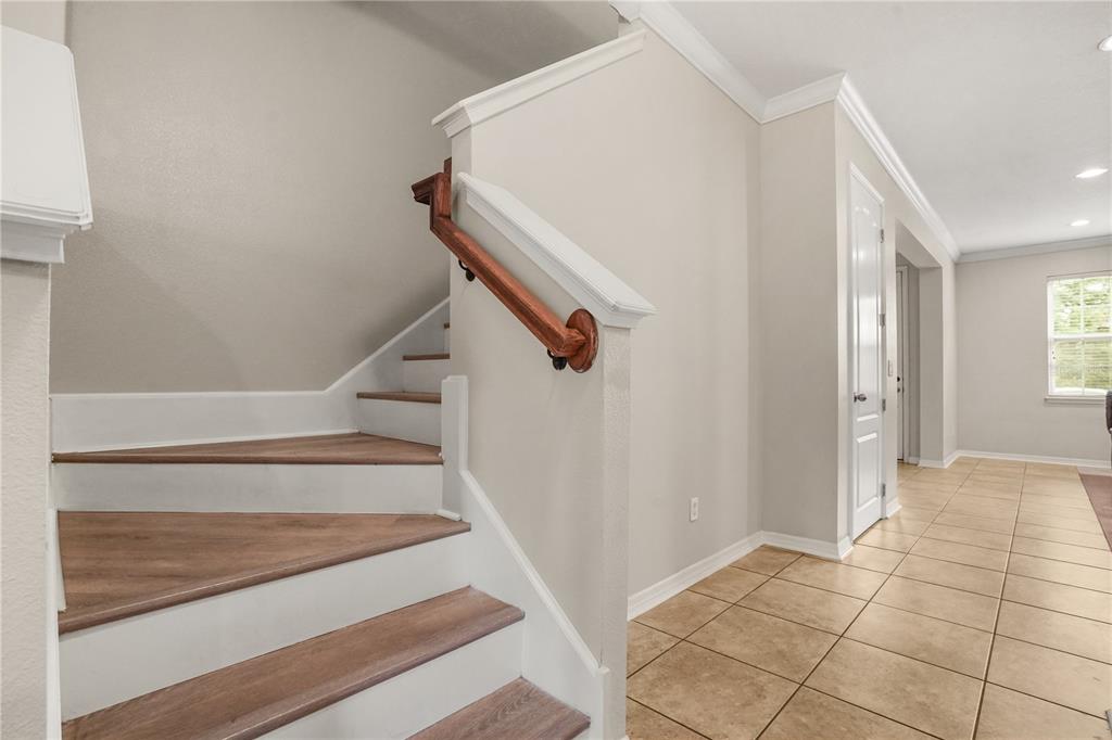 A living room features a wood floor inlay, tile flooring, leather recliners, and a television — 561 TELFAIR SQUARE COURT, SANFORD, FL