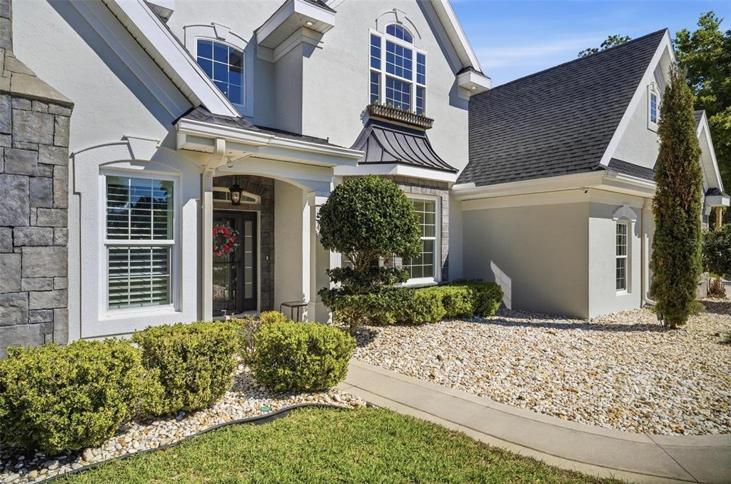 A two-story house with a stone facade, gray stucco, and a gravel front yard — 4105 PIUTE LANE, ORMOND BEACH, FL
